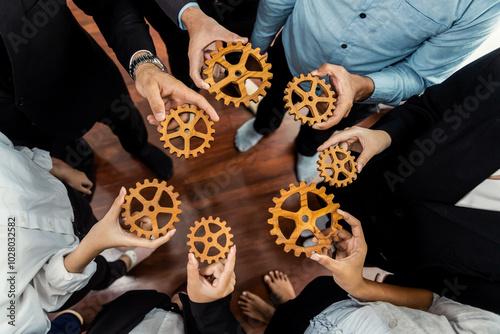 Group of multiracial business people joining gear wheels together as effective unity and productive teamwork concept. Efficient system business team process for solution solving. Meticulous