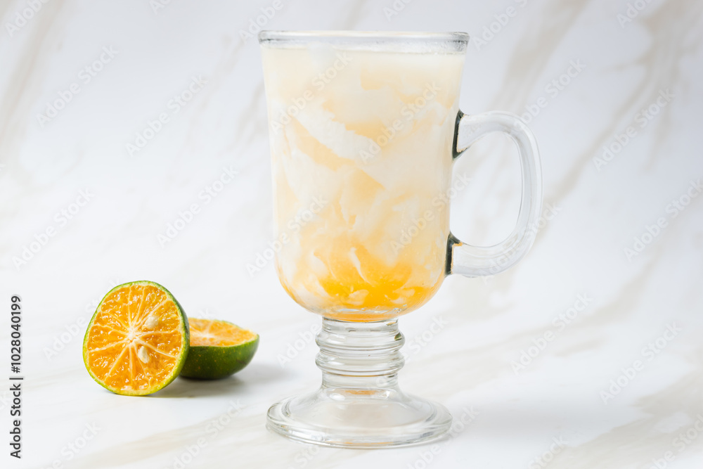 Es Kelapa Jeruk, a typical Indonesian drink made from fresh oranges squeezed with grated young coconut. with copy space. perfect for recipe, article, catalogue, or any commercial purposes.