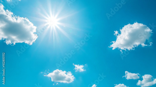 Bright sun shining in clear blue sky with few white clouds, creating serene atmosphere.
