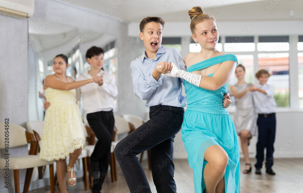 Obraz premium During rehearsal of reporting concert, adolescence boy and girl participants of dance workshop perform lindy hop under guidance of female mentor