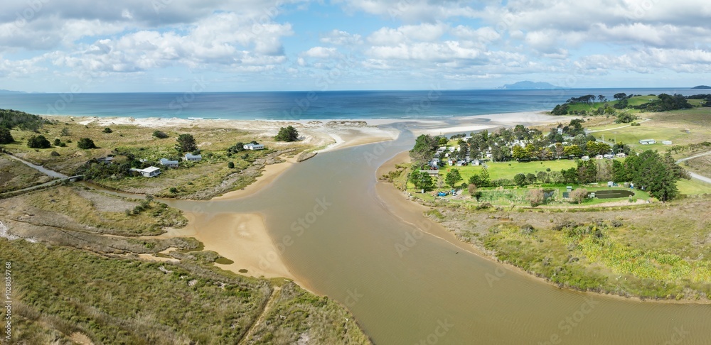 Holiday homes, campground and Pakiri River flowing into the ocean at Pakiri, Auckland, New Zealand. Holiday homes, campground and Pakiri River flowing into the ocean at Pakiri, Auckland, New Zealand.