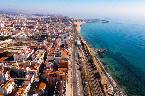 Aerial view of coastal town of Premia de Mar on Catalan coast of turquoise Mediterranean Sea with marina on warm winter day, Maresme, Spain