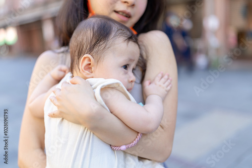 A 6-month-old baby held by a woman in her 30s inside a building near Dihua Street in Taipei City, Taiwan, in September. photo