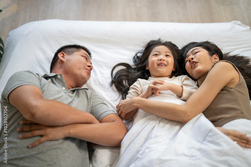 A joyful mother and daughter laughing together while lying on a bed. The playful moment showcases their strong bond and happiness in a comfortable home setting, surrounded by natural decor. A joyful mother and daughter laughing together while lying on a bed. The playful moment showcases their strong bond and happiness in a comfortable home setting, surrounded by natural decor.