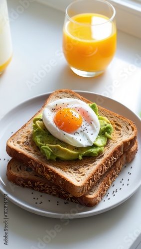 Healthy breakfast with avocado toast, poached egg, and orange juice