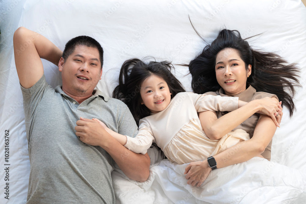 A joyful mother and daughter laughing together while lying on a bed. The playful moment showcases their strong bond and happiness in a comfortable home setting, surrounded by natural decor. A joyful mother and daughter laughing together while lying on a bed. The playful moment showcases their strong bond and happiness in a comfortable home setting, surrounded by natural decor.