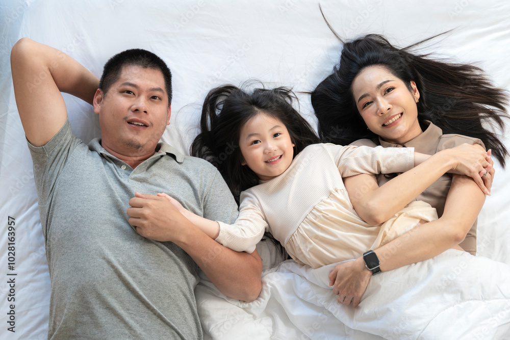 A joyful mother and daughter laughing together while lying on a bed. The playful moment showcases their strong bond and happiness in a comfortable home setting, surrounded by natural decor. A joyful mother and daughter laughing together while lying on a bed. The playful moment showcases their strong bond and happiness in a comfortable home setting, surrounded by natural decor.