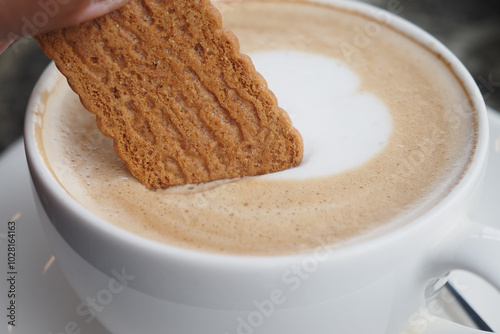 Dunking a Delicious Biscuit into a Warm and Inviting Cup of Freshly Brewed Coffee photo