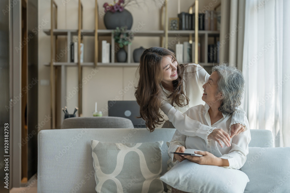 portrait of bonding senior mother and adult daughter,old woman sitting on couch,a young female standing behind and embracing her mom in living room,hugging with love, smile,affection portrait of bonding senior mother and adult daughter,old woman sitting on couch,a young female standing behind and embracing her mom in living room,hugging with love, smile,affection