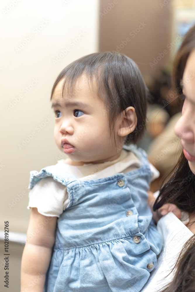 A 1 year old Taiwanese girl spending time with her parents, a man and woman in their 20s, near the entrance of a high rise apartment in Taichung City, Taiwan. A 1 year old Taiwanese girl spending time with her parents, a man and woman in their 20s, near the entrance of a high rise apartment in Taichung City, Taiwan.