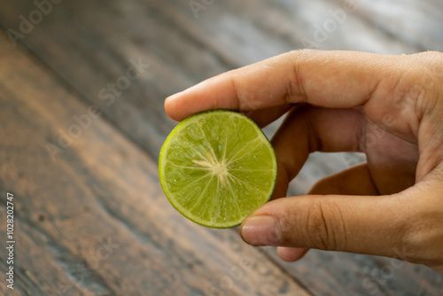 jeruk nipis or Lime green with cut in half and slices isolated on wooden background.