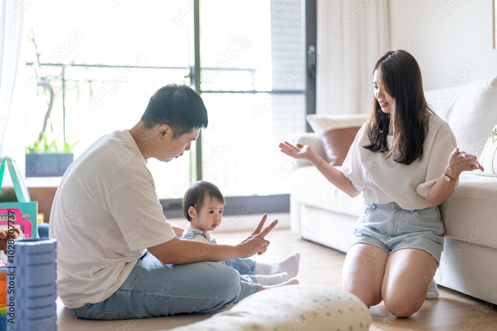 A 1 year old Taiwanese girl spending time playing happily with her parents, a man and woman in their 20s, in a room of a high rise apartment in Taichung City, Taiwan.