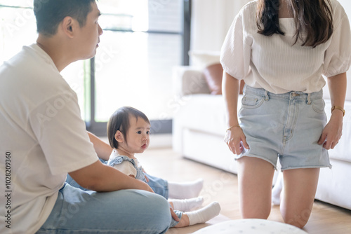 A 1 year old Taiwanese girl spending time playing happily with her parents, a man and woman in their 20s, in a room of a high rise apartment in Taichung City, Taiwan.