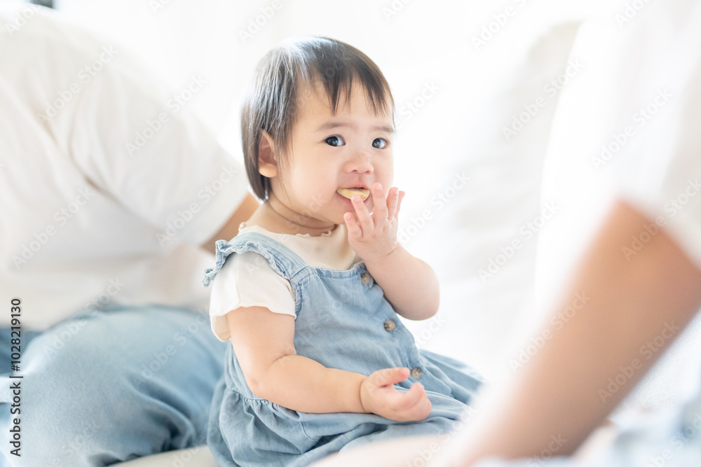 A 1 year old Taiwanese girl spending time playing happily with her parents, a man and woman in their 20s, in a room of a high rise apartment in Taichung City, Taiwan. A 1 year old Taiwanese girl spending time playing happily with her parents, a man and woman in their 20s, in a room of a high rise apartment in Taichung City, Taiwan.