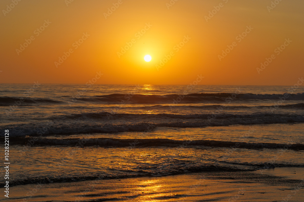 Vibrant Orange and Red Sunset Reflecting Over the Ocean Vibrant Orange and Red Sunset Reflecting Over the Ocean