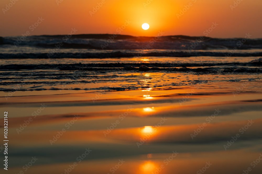Vibrant Orange and Red Sunset Reflecting Over the Ocean Vibrant Orange and Red Sunset Reflecting Over the Ocean