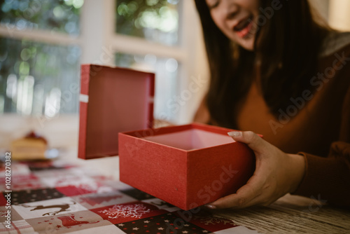 Happy excited asian woman hands holding Christmas gift box. cheerful girl packing Xmas present or open box xmas new year birthday gift.