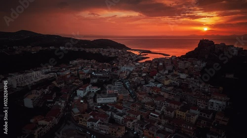 Drone view of Castelsardo old town and evening city lights at sunset, Sardinia island, time lapse photo