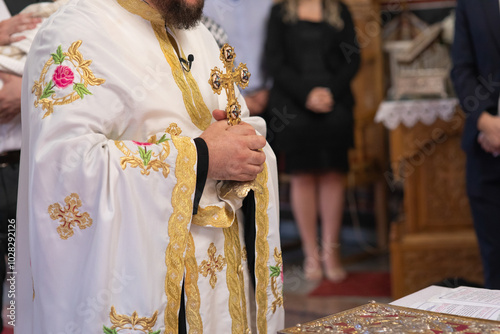 Fotografi A male priest holds a large Orthodox cross.
