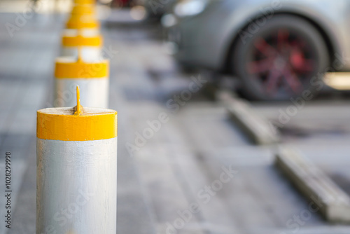 Steel pillar row for safety block between car parking lot and pedestrian walkway. Transportation safety equipment object, selective focus. photo