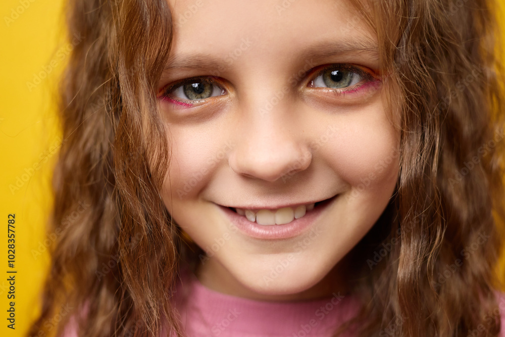 Closeup portrait of happy Caucasian little girl with trendy hairstyle smiling feeling joyful expressing positive emotions isolated over yellow background Closeup portrait of happy Caucasian little girl with trendy hairstyle smiling feeling joyful expressing positive emotions isolated over yellow background