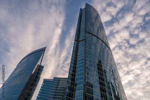 Angled view of modern skyscrapers in business district against blue sky. Looking Up high-rise office buildings.