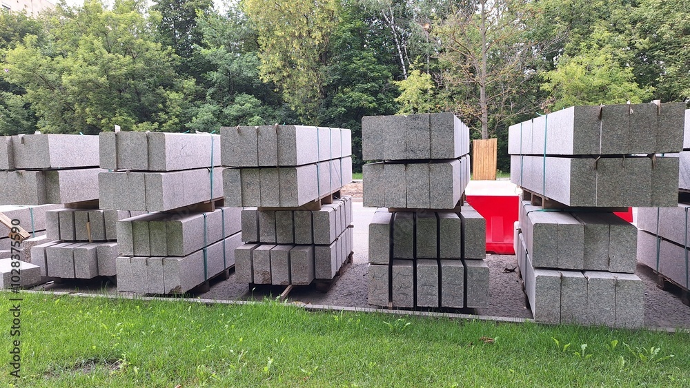 Stacks of construction concrete blocks on grass with forest background Stacks of construction concrete blocks on grass with forest background