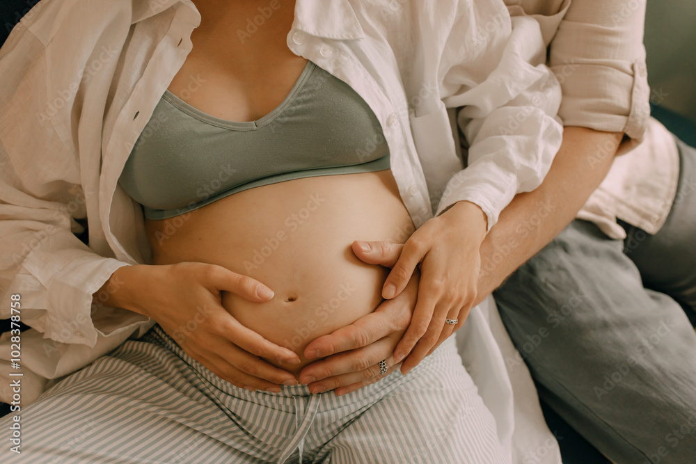 © Westend61 - Hand of man touching pregnant wife's belly