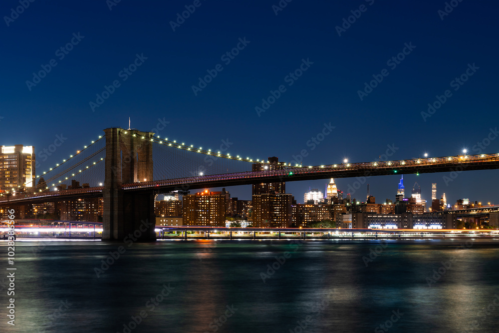 Fototapeta premium Brooklyn Bridge at Night with Manhattan Skyline in Background.