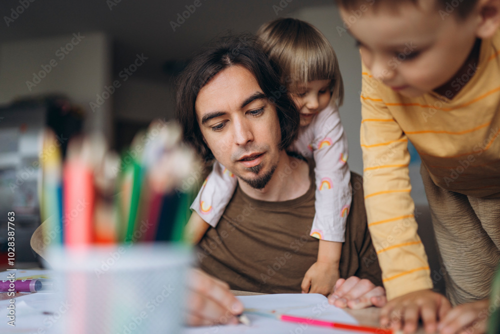 Father teaching drawing to children at home