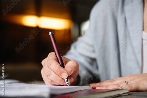 Hand of businesswoman writing with pen