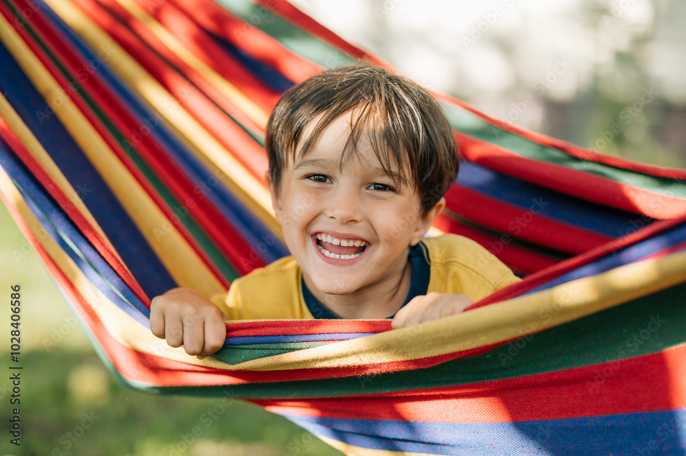 Happy boy in colorful hammock during summer vacation Happy boy in colorful hammock during summer vacation