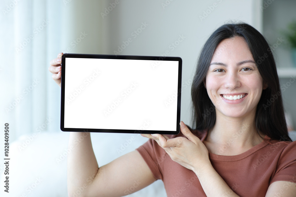 Happy asian woman showing blank tablet screen at home Happy asian woman showing blank tablet screen at home