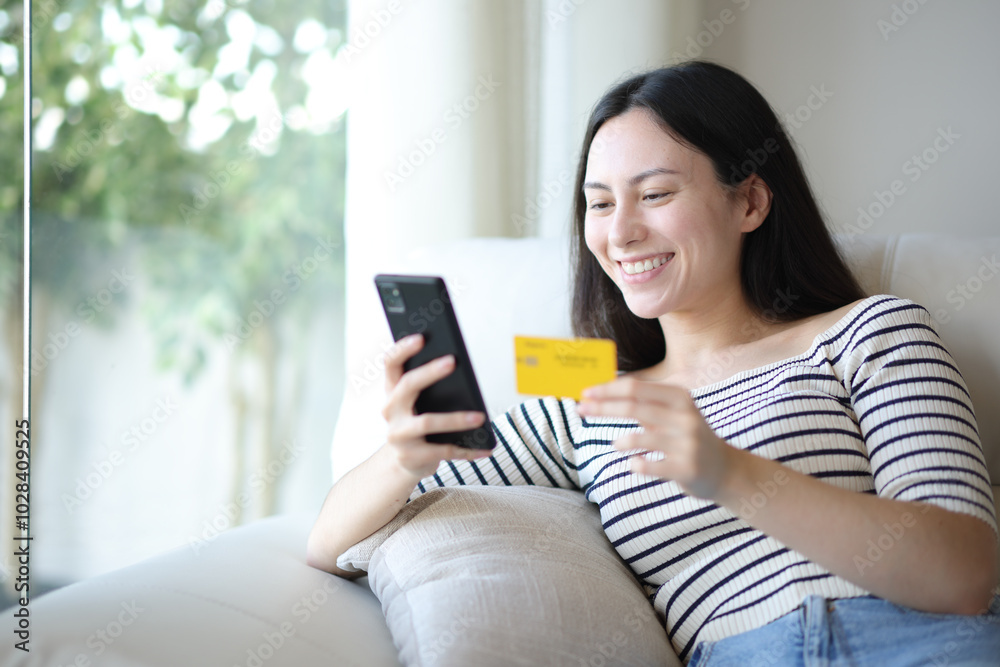 Happy asian woman buying online at home Happy asian woman buying online at home