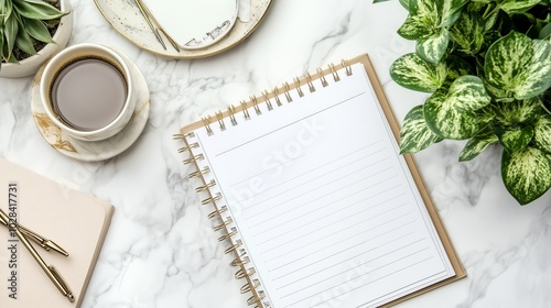 Flat lay with coffee, notebook, and plants on a marble desk