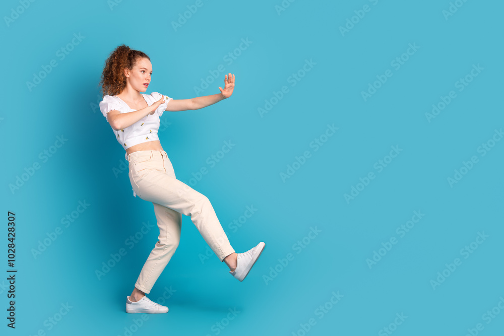 Full size photo of pretty young girl kick fighting wear trendy white outfit isolated on blue color background