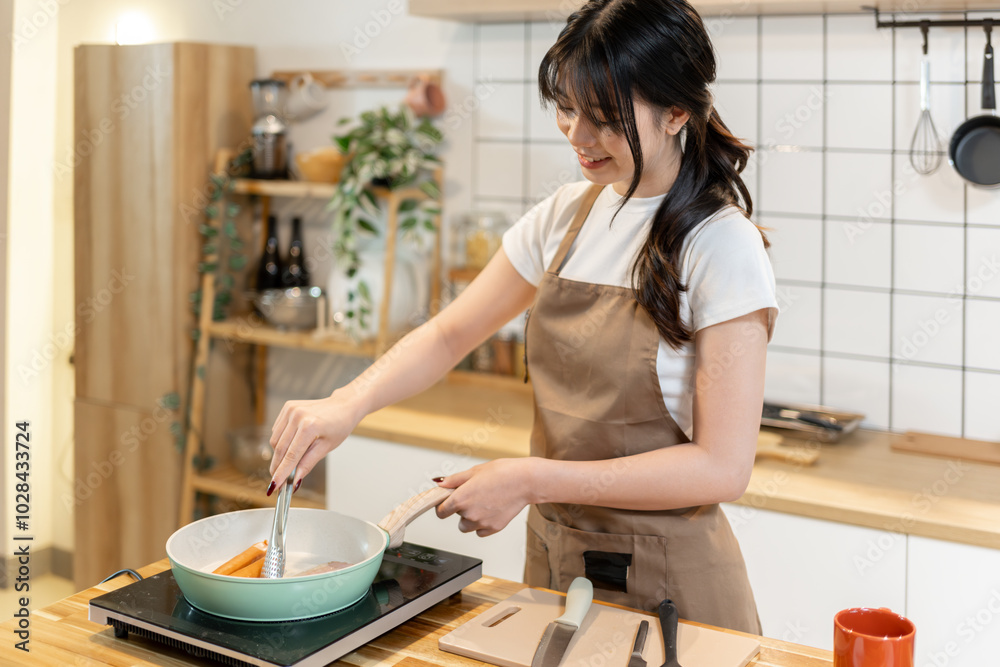 Asian woman grilling sausages and bacon for breakfast Asian woman grilling sausages and bacon for breakfast
