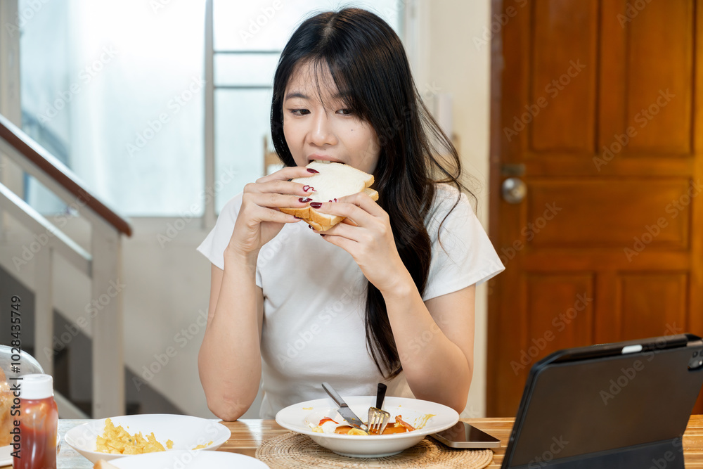 A happy Asian woman is having breakfast. A happy Asian woman is having breakfast.