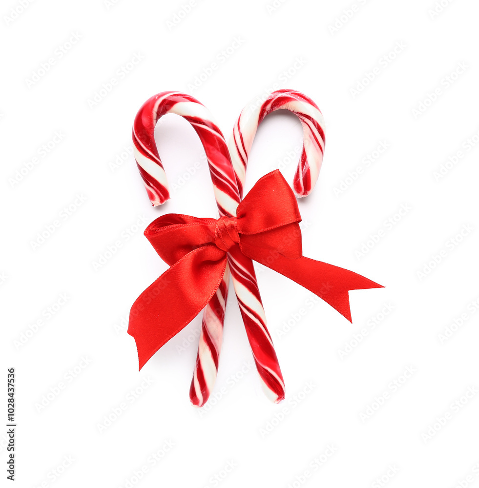 Christmas candy canes with bow on white background Christmas candy canes with bow on white background