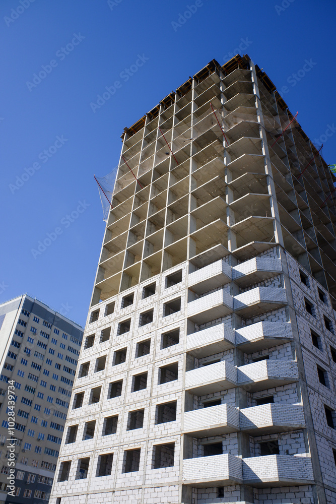 A large building is under construction with scaffolding and cranes A large building is under construction with scaffolding and cranes
