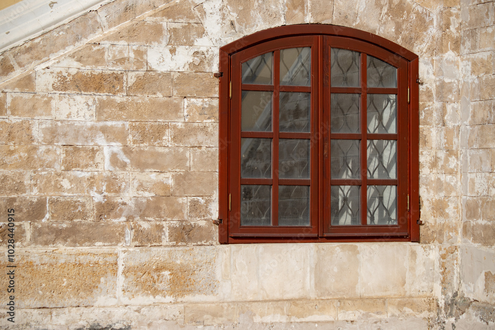 A window with a wooden frame and a stone wall behind it A window with a wooden frame and a stone wall behind it