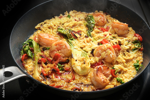 Curry rice pan with shrimps and vegetables, cooking a rustic homemade meal, selected focus