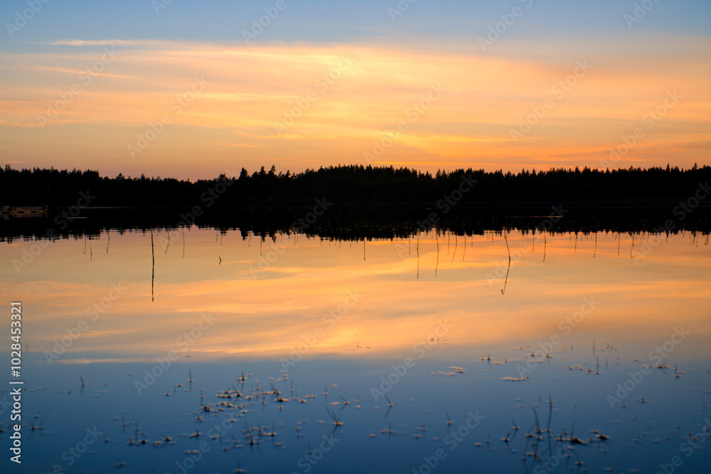 Obraz premium Sunset with warm colors on a Swedish lake in Smalland. Romantic evening atmosphere