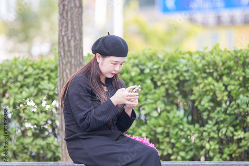 A Japanese woman in her 30s is enjoying a relaxing afternoon at a stylish cafe's terrace in Gyeongchun-ro, Namyangju-si, Gyeonggi-do, Korea. photo