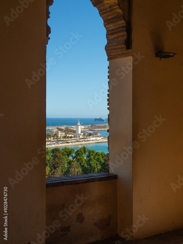 View of La farola, lighthouse of Malaga and transatlantic through a window- Spain