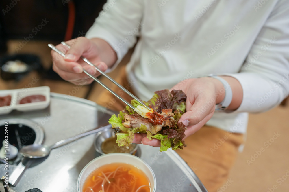 A Korean man and a Japanese woman, both in their 30s and a married couple, are enjoying a meal of Samgyeopsal at a famous restaurant in Jung District, Seoul, Korea, on an autumn night in October. A Korean man and a Japanese woman, both in their 30s and a married couple, are enjoying a meal of Samgyeopsal at a famous restaurant in Jung District, Seoul, Korea, on an autumn night in October.
