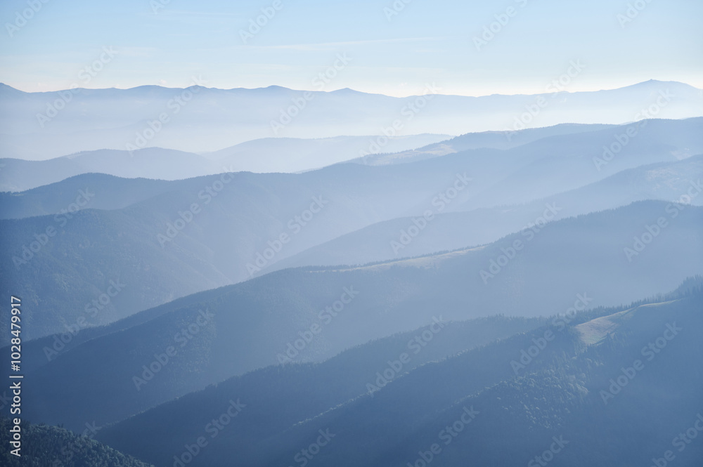 Soft blue hues of layered mountain ranges stretch into the distance under clear sky, creating tranquil and atmospheric landscape filled with gentle gradients and sense of vastness. Soft blue hues of layered mountain ranges stretch into the distance under clear sky, creating tranquil and atmospheric landscape filled with gentle gradients and sense of vastness.