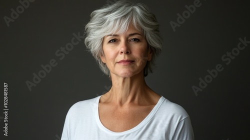 Beautiful older woman in white t-shirt female breast dark background Breast cancer support, prevention, mammography, screening, oncology, cancer treatment