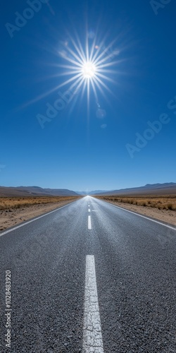 A stunning view of a long, straight road under a bright sun in a vast desert landscape.