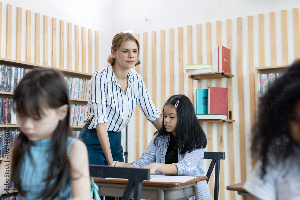 female teacher is teaching girls in class. School children education in classroom. kid schoolgirl happy learning. Writing as instructed by teacher. concept of back to school. female teacher is teaching girls in class. School children education in classroom. kid schoolgirl happy learning. Writing as instructed by teacher. concept of back to school.